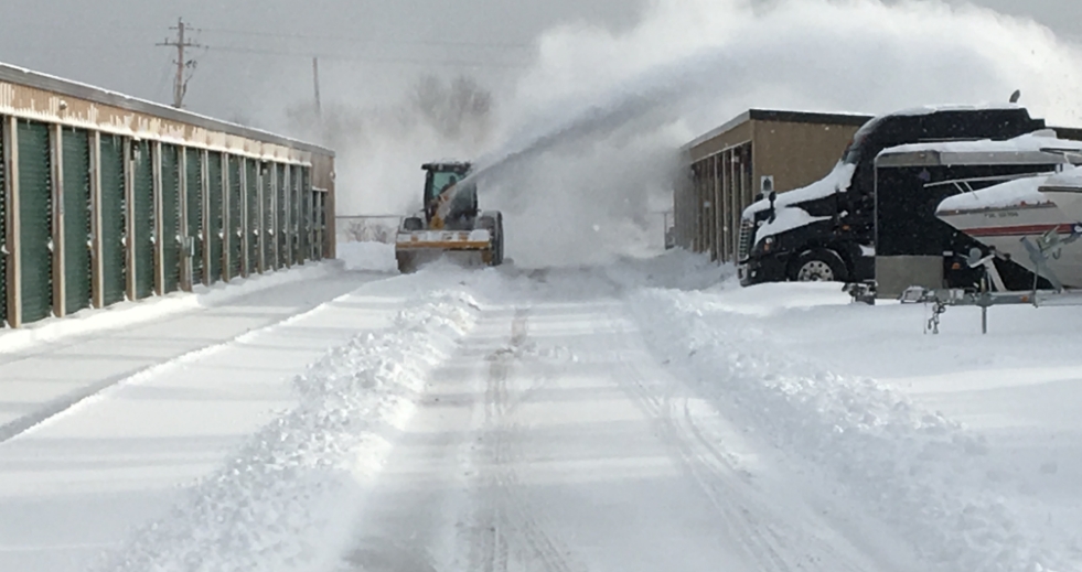 A picture of a snow plow doing industrial snow removal in barrie at a storage facility