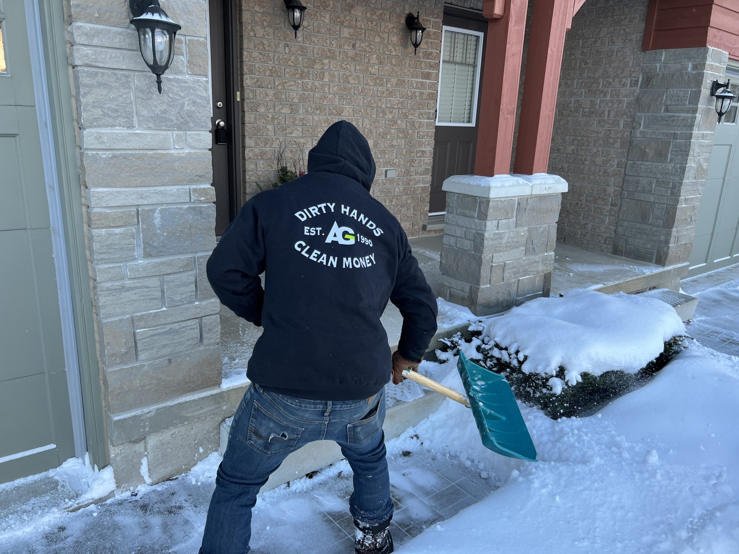 Snow pusher clearing a residential walkway during winter in Collingwood Ontario