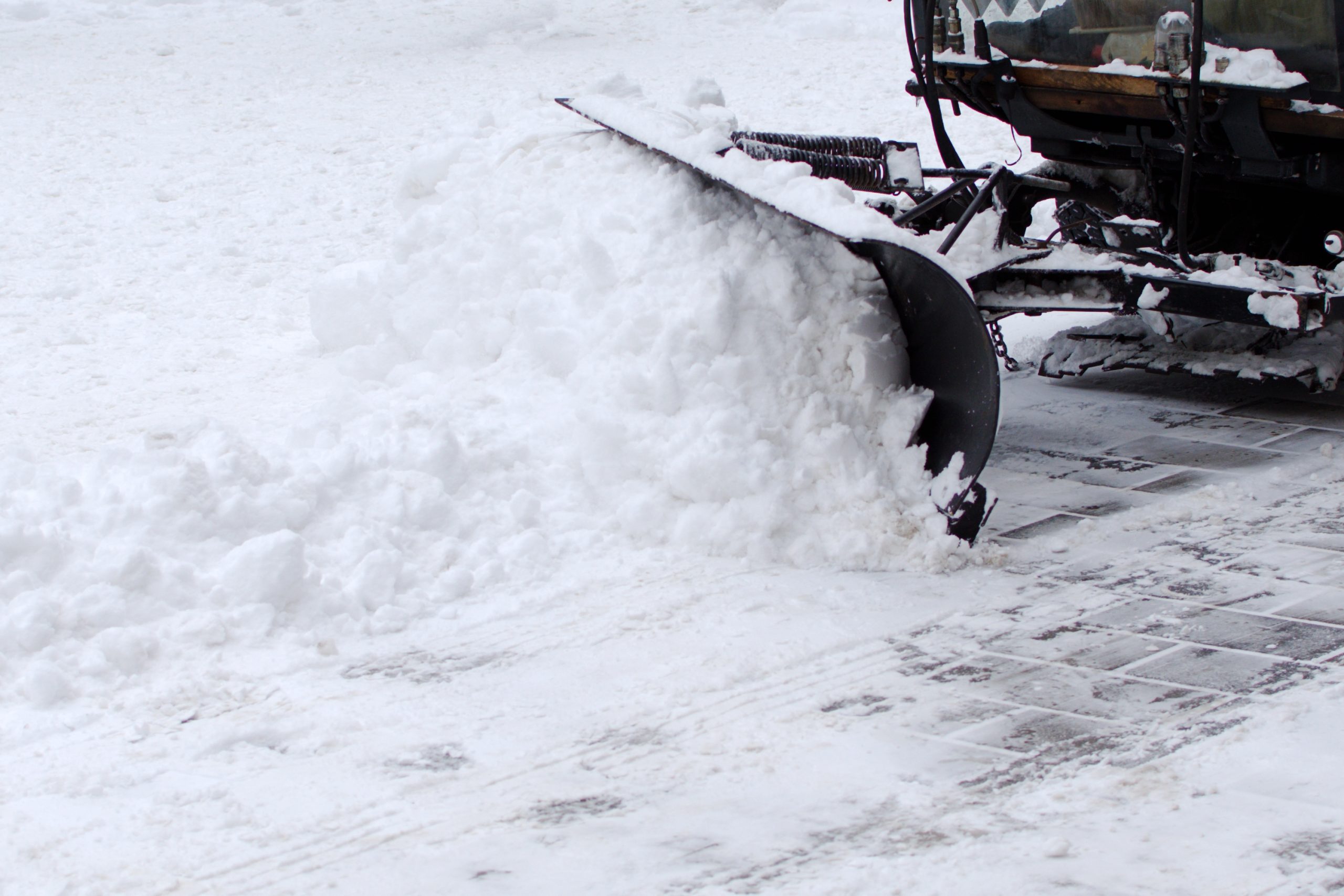 Commercial snowplow clearing heavy snow from an Ontario property
