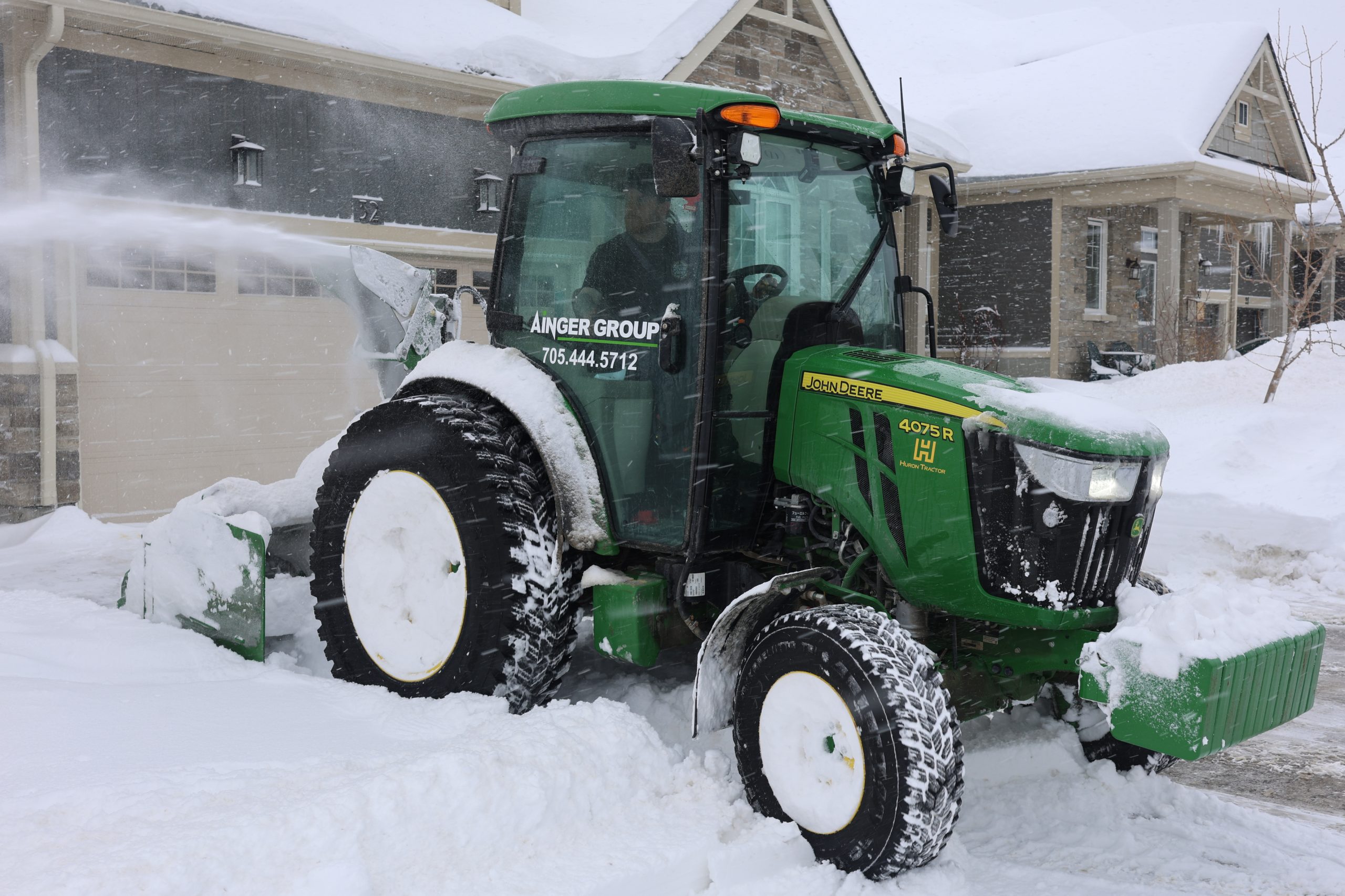 Powered snow blower equipment clearing snow at a residential property in Collingwood Ontario robot