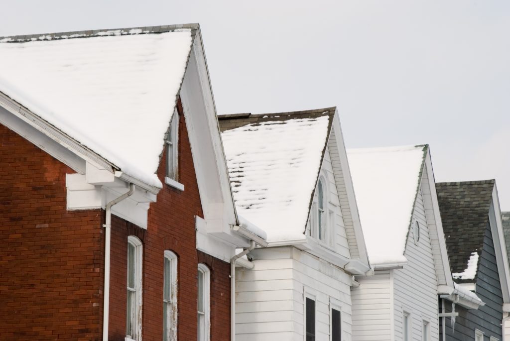 Snow-covered residential roofs during winter in Collingwood Ontario