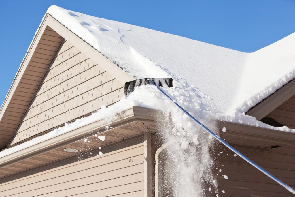 Snow rake removing roof snow from a home in Collingwood Ontario