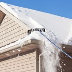 Snow rake removing roof snow from a home in Collingwood Ontario